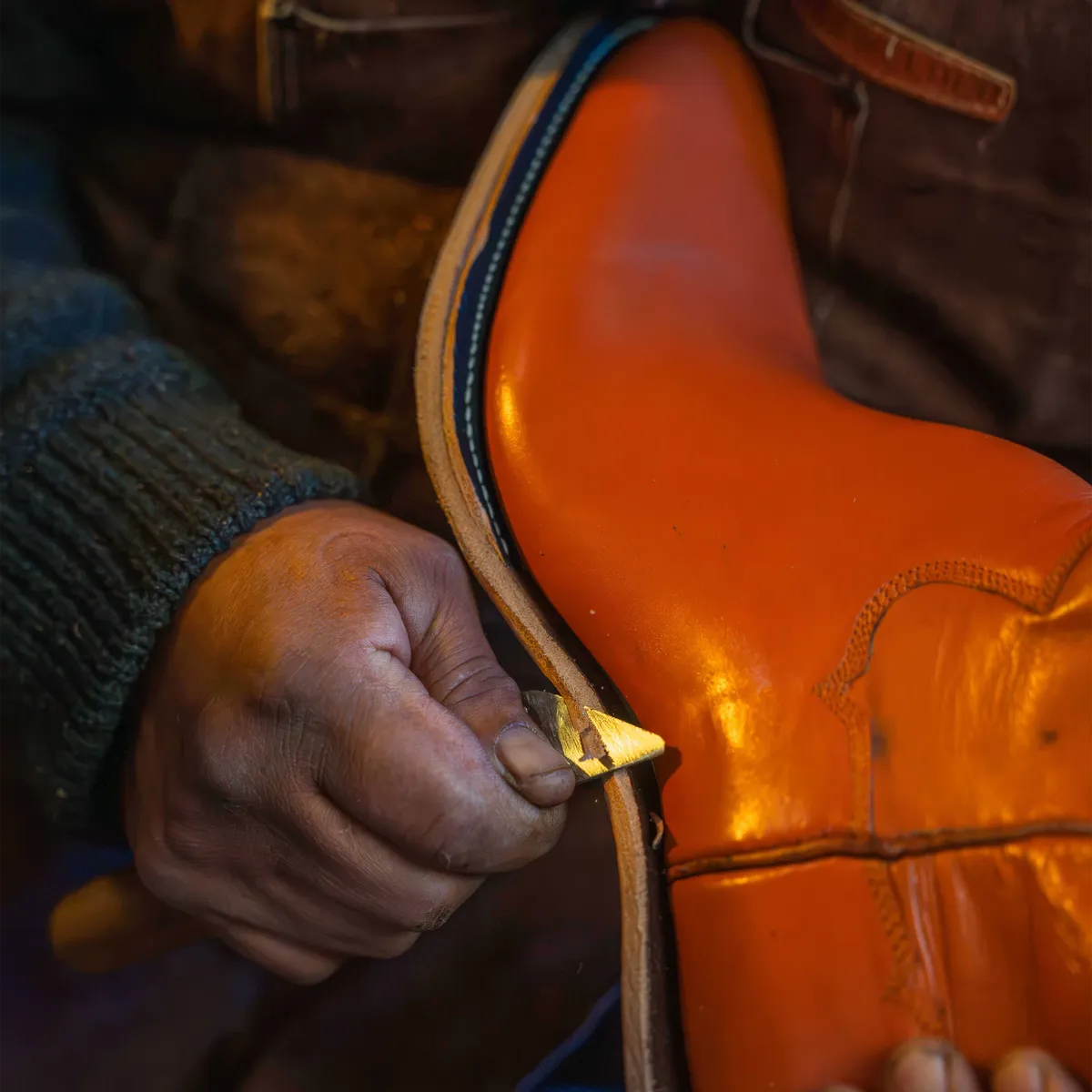 A bootmaker's hands finishing a boot
