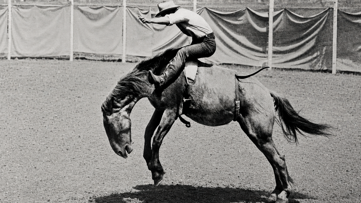 Paul Bond riding a bucking bronc at a rodeo, vintage photograph